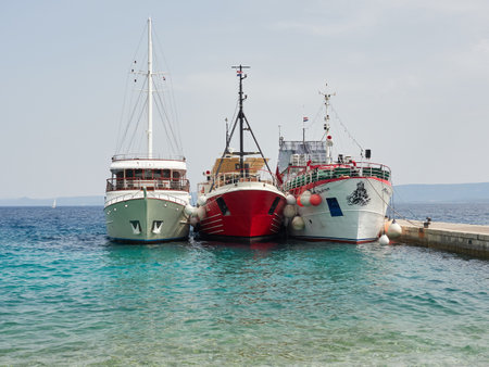 Bol, Croatia, July 25, 2021: three ships berthed side by side in the port. Ship mooring in a small port on the island of Brac. Ships in the Adriatic Seaのeditorial素材