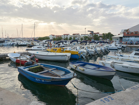 Vodice, Croatia July 28, 2021: Sea harbor at sunset with moored boats for rent.のeditorial素材