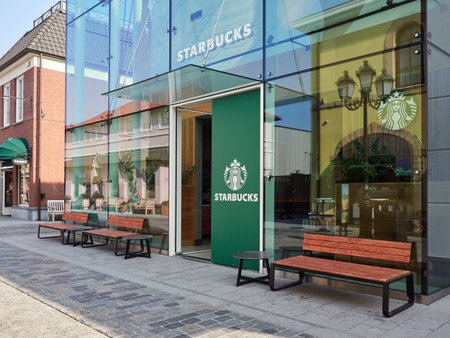 Roermond, The Netherlands, March 25, 2022 - Entrance to the glazed and modern Starbucks coffee shop building at Designer Outlet Roermond.のeditorial素材