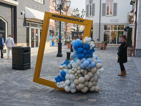 Roermond, The Netherlands, March 25, 2022 - Large wooden photo frame for Designer Outlet Roermond customers decorated with colorful balloons.のeditorial素材