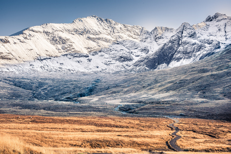 Path and winter scenery in the mountains - snow covered rocky summits of Cuillins in Glenbrittle, Isle of Skye, Scotlandの写真素材