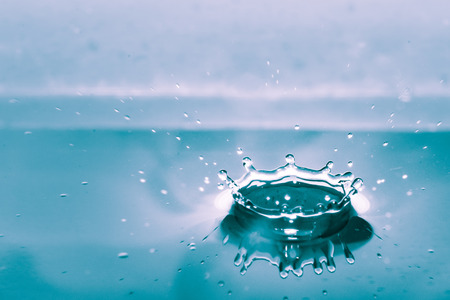 Water splash isolated on blue backgroundの写真素材