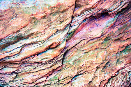 Green, orange, yellow sediments and minerals, rock formations - a colorful rocks stacked over the...