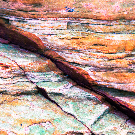 Green, orange, yellow sediments and minerals, rock formations - a colorful rocks stacked over the hundreds of yearsの写真素材