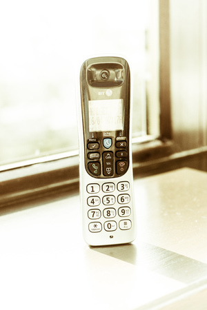 Traditional landline phone isolated on wooden desk backgroundの写真素材