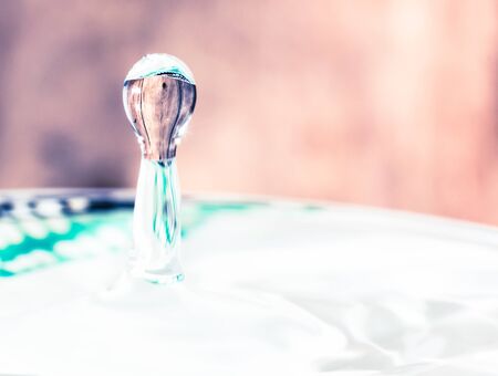 Bouncing water droplet on dark background