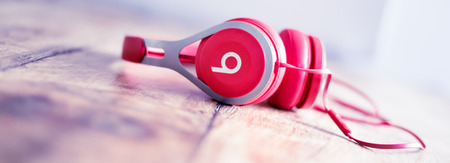 Alloa, Scotland - July 17 2019: Beats Headphones by Dr. Dre isolated on unfocused wooden background
