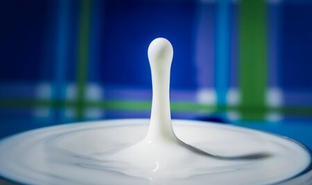 Fresh milk droplet isolated on interesting colourful background - dairy products - lactose intoleranceの写真素材