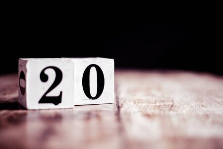 Number 20 isolated on dark background- 3D number twenty isolated on vintage wooden tableの写真素材