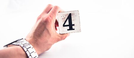 A hand holding digit number 4 (four) on white backgroundの写真素材