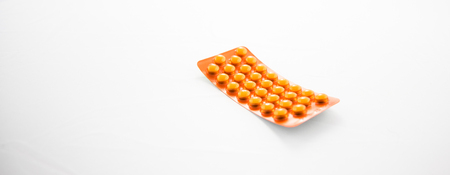 Alloa, Scotland - 13 August 2019: Yellow tablets in orange blisterのeditorial素材