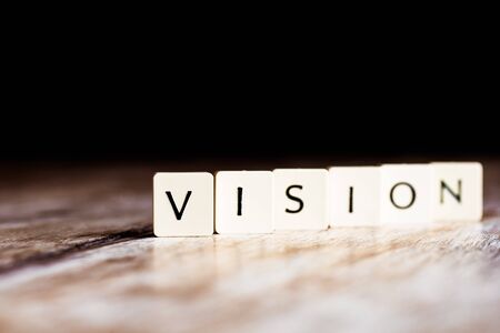 Vision word made of tiles on dark wooden backgroundの写真素材
