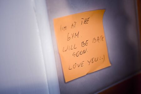 I'm at the gym. Will be back soon note on a sticky notesの写真素材