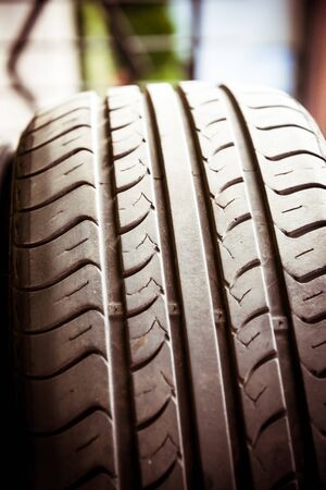 Close up of car tyre tread on the road on a bright day
