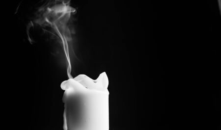 One light candle burning brightly in the black backgroundの写真素材