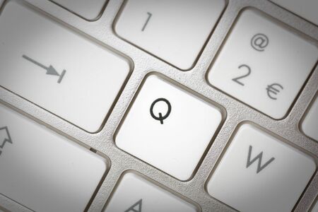 Computer keyboard - silver keyboard of a laptop with button Q isolated. Home office with portable modern technology, IT and computing.の写真素材
