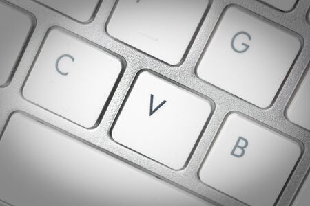 Computer keyboard - silver keyboard of a laptop with button V isolated. Home office with portable modern technology, IT and computing.の写真素材