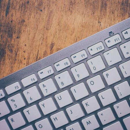 Retro effect computer keyboard on old vintage wooden tableの写真素材