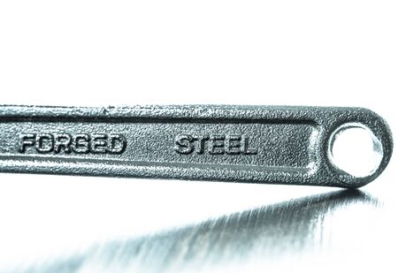 Blurry forged steel sign on a wrench isolated on white background - handtools for DIY.の写真素材