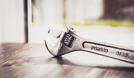 French key, wrench, made with forged steel isolated on wooden worktopの写真素材