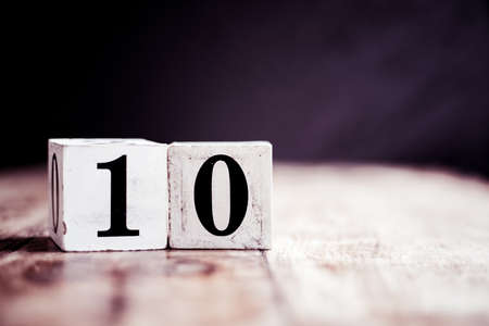 Number 10 isolated on dark background- 3D number ten isolated on vintage wooden tableの写真素材