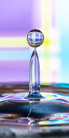 Perfect water droplet on light blue and violet background - water issues, water shortage, resourcesの写真素材