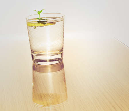 Glass of water with slice of lemon and mint - refreshing beverageの写真素材