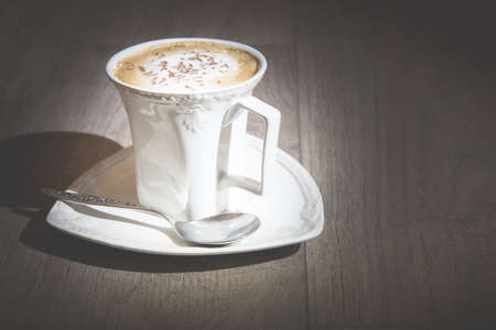 Cup of cappuccino coffee on vintage wooden tableの写真素材