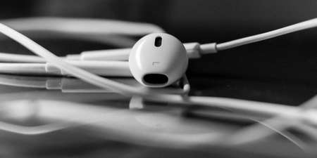 White earphones isolated on glass bokeh backgroundの写真素材