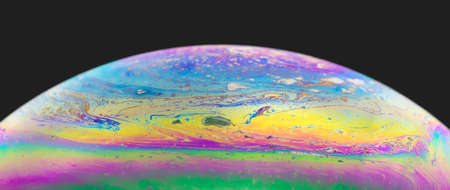 Blurred colourful soap bubble close up on black background. Creative background. Concept of space...