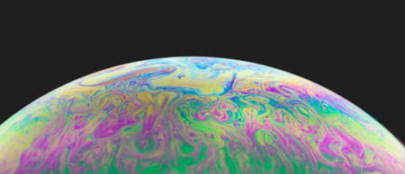 Blurred colourful soap bubble close up on black background. Creative background. Concept of space...