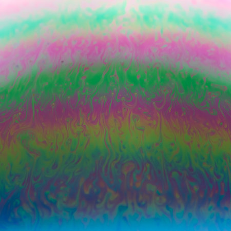 Blurred colourful soap bubble close up on black background. Creative background. Concept of space...