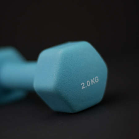 2 kg dumbbells isolated on dark background - home fitness and workout.の写真素材