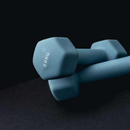 2 kg dumbbells isolated on dark background - home fitness and workout.の写真素材