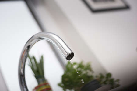 Kitchen tap isolated on bright background. Water saving solutions.
