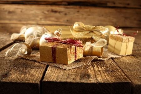 golden gift boxes on rustic plank tableの写真素材