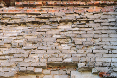 Background of old vintage dirty brick wall with peeling plaster, texture.の写真素材