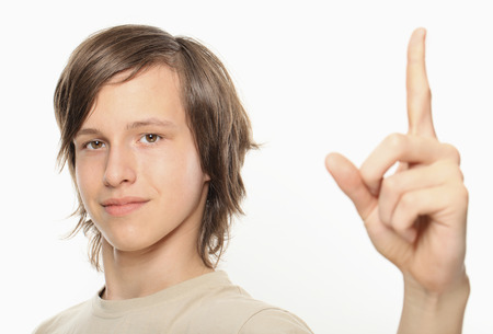 Young boy showing upwards with index fingerの写真素材
