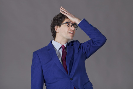 Guy with curly hair and blue jacket forget of something importantの写真素材