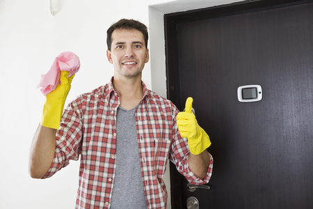 Ready to clean up. Smiling young husband standing with ok gestureの写真素材