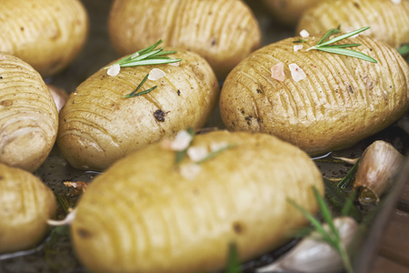 Rustic Hasselback potatoes with herbs, garlic and salt, vegetarian good quality foodの写真素材