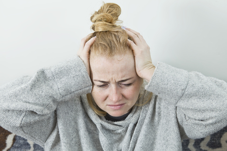 Stressed exhausted young woman having strong tension headache.の写真素材