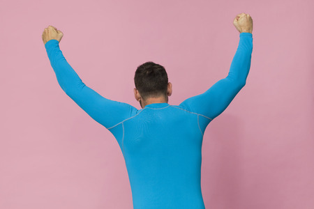Tall man back portrait in blue sport shirt, isolated on pinkの写真素材