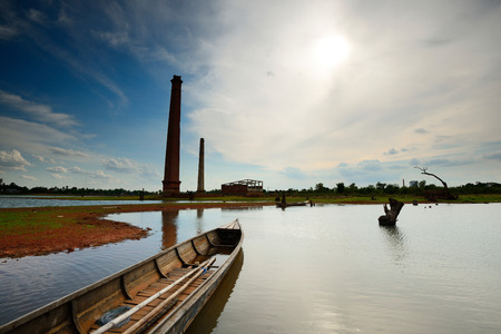 Old decaying factory building with reflections in lakeの写真素材