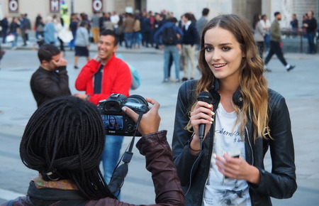 MILAN, ITALY - SEPTEMBER 26, 2015: A Young Model Interviewing in the Square during Milan's Fashion Week Woman Fall / Winter 2015のeditorial素材