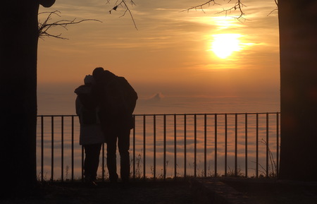 Couple admiring fog on the lowland at the sunset.の写真素材