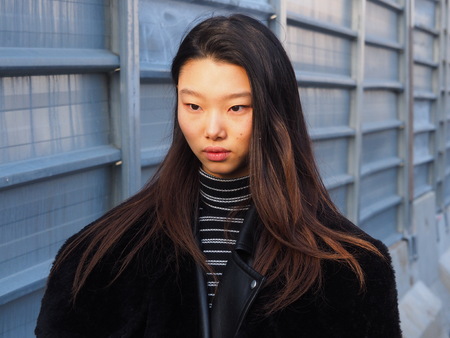 MILAN - JANUARY 14: Asian woman posing in the street after DSQUARED2 fashion show, during Milan Fashion Week Man fall / winter 2018/19 on January 14, 2018 in Milan, Lombardy, Italy.のeditorial素材