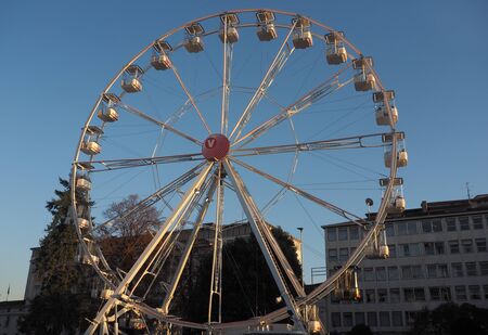 Bergamo, Italy: November 25, 2019: Ferris Wheel against the Blue Sky in the city center of Bergamo Sunny Day. Rotating Ferris wheel with cabins.の写真素材