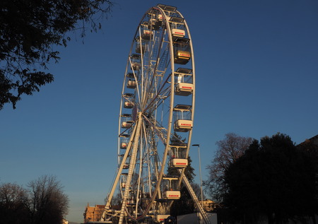 Bergamo, Italy: November 25, 2019: Ferris Wheel against the Blue Sky in the city center of Bergamo Sunny Day. Rotating Ferris wheel with cabins.のeditorial素材