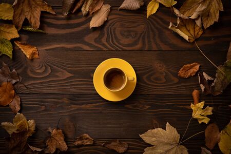 Autumn leaves on a wooden background and cup of Italian espresso coffeeの写真素材